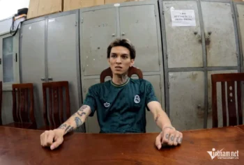 Rapper Bình Gold – tên thật là Vũ Xuân Bình, sinh năm 1997 – đang trở thành tâm điểm chỉ trích dữ dội trên mạng xã hội sau khi bị Công an TP Hà Nội bắt giữ vì hành vi cướp tài sản. Sự việc gây rúng động này xảy ra vào sáng ngày 26/7, khi Bình bất ngờ chiếm đoạt một chiếc taxi giữa ban ngày tại khu vực gần chung cư Ciputra, phường Phú Thượng. Đáng nói, lý do được chính đối tượng đưa ra cho hành vi liều lĩnh của mình lại càng khiến dư luận sửng sốt: **“Vì vội về Quảng Ninh gặp bạn”**. Theo thông tin từ cơ quan chức năng, khoảng 9h10 sáng, tài xế taxi N.V.B đang đỗ xe chờ khách thì Vũ Xuân Bình xuất hiện và thuê xe đi gấp. Ngay từ lúc lên xe, Bình đã thể hiện thái độ vội vàng, liên tục giục tài xế di chuyển nhanh hơn. Anh ta còn đề nghị được vay 30.000 đồng để mua nước và thuốc lá nhưng bị tài xế từ chối. Khi xe đến đoạn đường Vành đai 3, đối diện BigC Thăng Long, gặp tình trạng ùn tắc giao thông, Bình bắt đầu tỏ ra mất kiểm soát. **“Tôi chửi và yêu cầu đi vào làn đường khẩn cấp nhưng tài xế không đồng ý. Tôi dùng ngón tay kề vào cổ lái xe, đe dọa ‘vượt đi’”**, Bình khai tại cơ quan điều tra. Trước sự kiên quyết của người tài xế, rapper này không ngần ngại sử dụng vũ lực: anh ta túm cổ áo, đạp vào ghế lái, gây áp lực buộc tài xế phải rời khỏi vị trí điều khiển. Quá hoảng sợ, tài xế B. đã tháo dây an toàn và mở cửa bỏ chạy, để lại chiếc xe vẫn còn đang nổ máy. Bình lập tức nhảy sang ghế lái và điều khiển xe bỏ chạy theo làn khẩn cấp hướng về phía cầu Thanh Trì. Trên đường tẩu thoát, Bình phát hiện ví và điện thoại của tài xế vẫn còn trong xe, tuy nhiên điện thoại bị khóa nên không thể mở được. Khi đến khu vực đê Xuân Quan, Bình dừng xe, mở ví lấy 50.000 đồng và ghé mua nước ngọt, thuốc lá cùng bật lửa. Chính tại thời điểm này, tổ công tác của Công an phường Đại Mỗ đã xuất hiện kịp thời và khống chế thành công đối tượng. Chiếc taxi cùng toàn bộ tài sản của tài xế đều được thu hồi nguyên vẹn. Tại trụ sở công an, Vũ Xuân Bình khai rằng mình không có ý định gây hại cho tài xế, mà chỉ vì quá nôn nóng muốn gặp bạn ở Quảng Ninh nên mới hành động liều lĩnh. **“Tôi chỉ muốn đi nhanh chứ không định làm gì tài xế”**, lời biện hộ mà theo nhiều người, hoàn toàn không thể bào chữa cho một hành vi cấu thành tội phạm cướp tài sản. Không dừng lại ở đó, kết quả kiểm tra ban đầu còn cho thấy Bình có dấu hiệu sử dụng ma túy, cụ thể là cần sa. Khi bị hỏi về nguồn gốc, anh ta khai đã hút cách đó một tuần và mua cần sa ở Hải Phòng, song không nhớ địa chỉ cụ thể. Dù lượng chất kích thích chưa được xác minh rõ ràng vào thời điểm gây án, nhưng thông tin này càng khiến hình ảnh của Bình Gold trở nên tồi tệ hơn trong mắt công chúng. Bình Gold không phải là cái tên xa lạ trong giới underground Việt Nam. Anh từng nổi danh qua những bản rap mang màu sắc ngông cuồng, lời lẽ thô tục, phong cách nổi loạn. Tuy nhiên, sự nghiệp âm nhạc của anh cũng gắn liền với nhiều tranh cãi, trong đó có việc từng bị cấm sóng vì ca từ phản cảm. Trước scandal lần này, Vũ Xuân Bình từng nhiều lần bị nhắc tên vì hành vi gây sốc trên mạng xã hội. Vụ việc hiện vẫn đang được Công an TP Hà Nội tiếp tục điều tra, làm rõ các yếu tố cấu thành tội phạm. Trong khi đó, cư dân mạng lẫn giới nghệ sĩ không giấu được sự thất vọng. Nhiều người cho rằng hành động của Bình không chỉ vi phạm pháp luật, mà còn đặt ra dấu hỏi lớn về trách nhiệm của một người làm nghệ thuật. Với những gì đã xảy ra, khả năng nam rapper phải đối mặt với án phạt nghiêm khắc là điều hoàn toàn có thể dự đoán. Bình Gold cướp taxi vì ‘vội về Quảng Ninh gặp bạn’